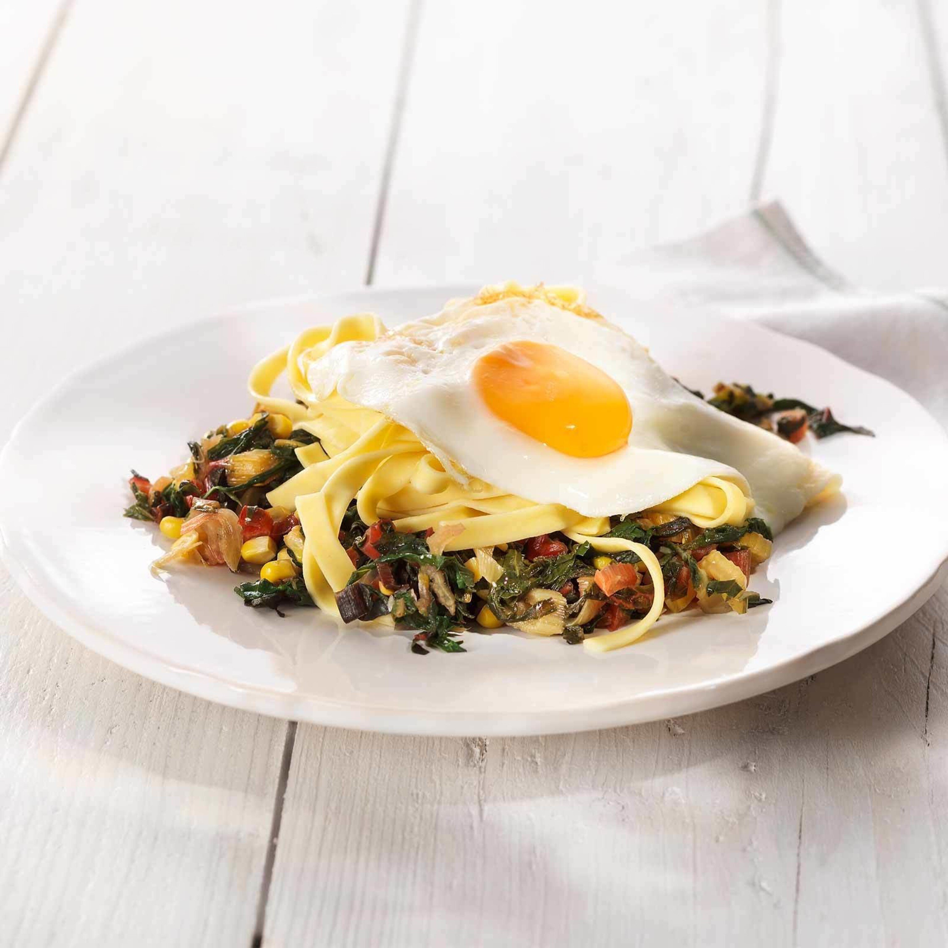 Tagliatelles et œuf au plat sur légumes